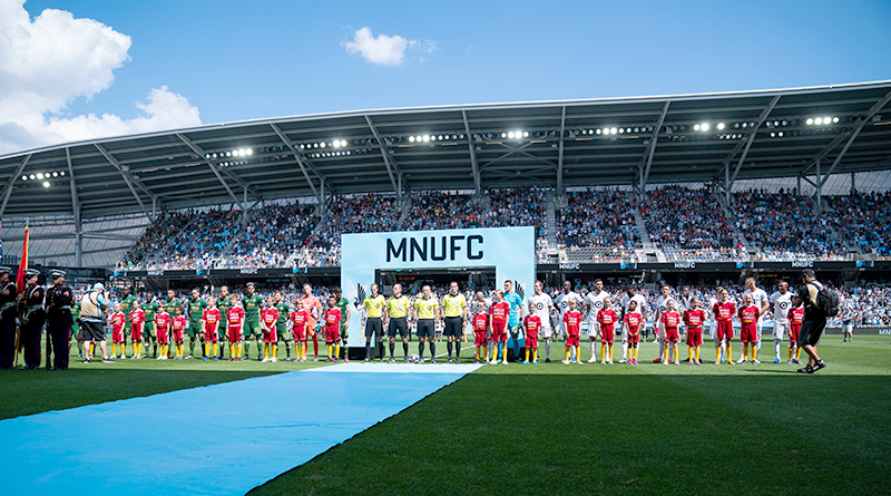 Players from the Minnesota United and the Portland Timbers stand for the national anthem before a game at Allianz Field.