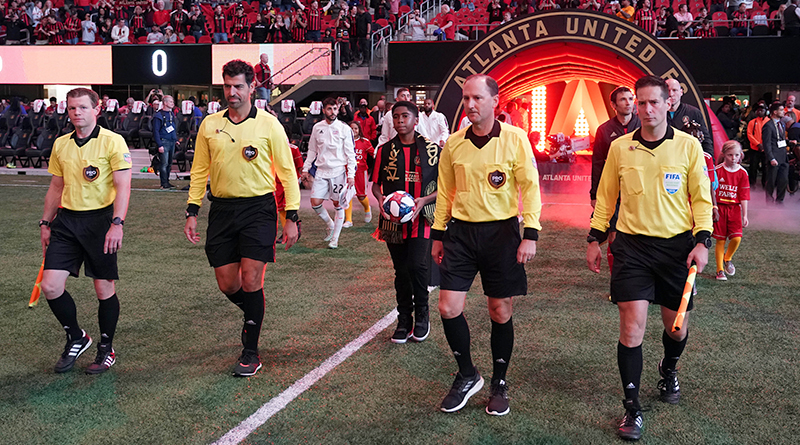 PRO officials lead the teams out to the field before the start of the Atlanta United match against the New England Revolution at Mercedes-Benz Stadium.