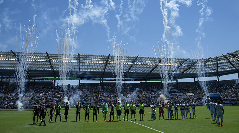 Austin FC and Sporting Kansas City players line up for the national anthem before the match at Children's Mercy Park.